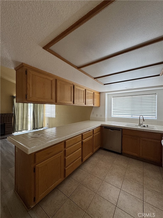 3178 Dogwood Dr, Corona, CA 92882 - kitchen with dishwasher, a sink, a textured ceiling, tile counters, and a peninsula