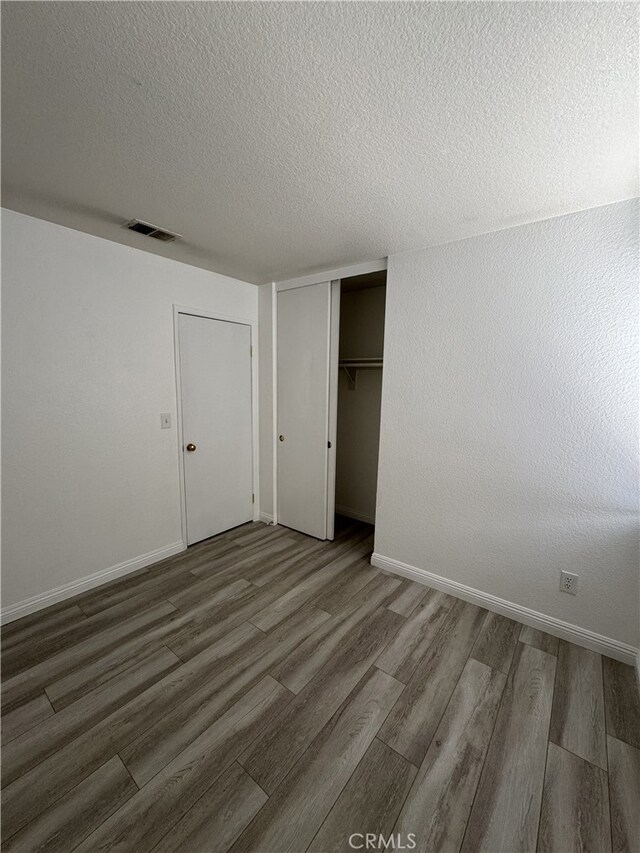 3178 Dogwood Dr, Corona, CA 92882 - unfurnished bedroom featuring wood finished floors, baseboards, a closet, and a textured ceiling