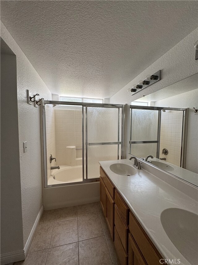 3178 Dogwood Dr, Corona, CA 92882 - bathroom featuring a textured wall, double vanity, combined bath / shower with glass door, baseboards, and a textured ceiling