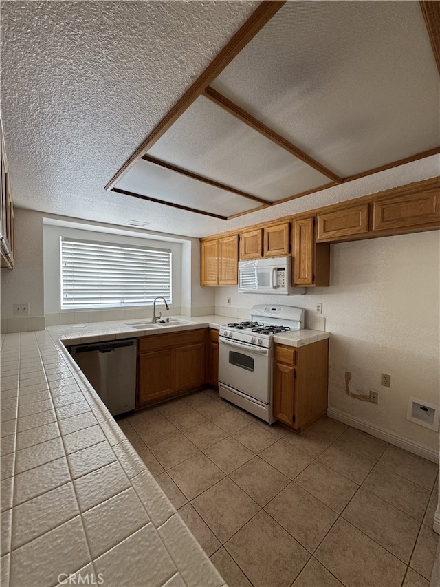 3178 Dogwood Dr, Corona, CA 92882 - kitchen with white appliances, a textured ceiling, tile countertops, a sink, and light tile patterned floors
