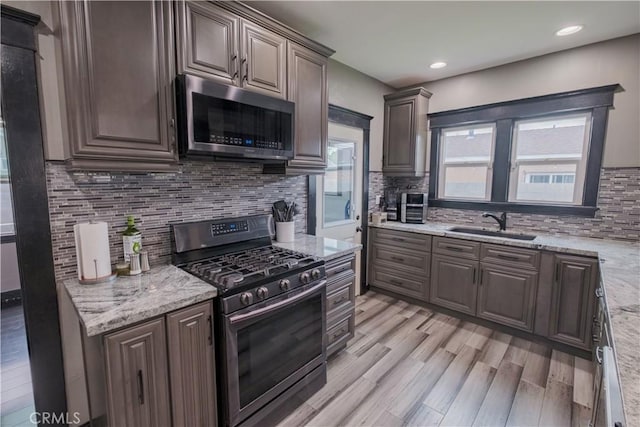 5837 Esperanza Ave, Whittier, CA 90606 - kitchen with stainless steel appliances, a sink, light wood finished floors, decorative backsplash, and recessed lighting