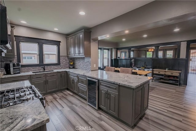 5837 Esperanza Ave, Whittier, CA 90606 - kitchen featuring wine cooler, tasteful backsplash, a peninsula, light wood-style flooring, and recessed lighting