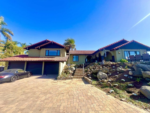 2073 Elevado Rd, Vista, CA 92084 - view of front of home with a tile roof, stucco siding, an attached garage, and stairway