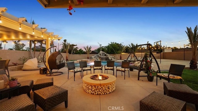 17623 Pine Ave, Fontana, CA 92335 - patio terrace at dusk featuring a patio, a fenced backyard, and an outdoor living space with a fire pit