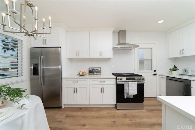 3037 Pacific Ave, Long Beach, CA 90806 - kitchen with stainless steel appliances, wall chimney range hood, a chandelier, light countertops, and white cabinets