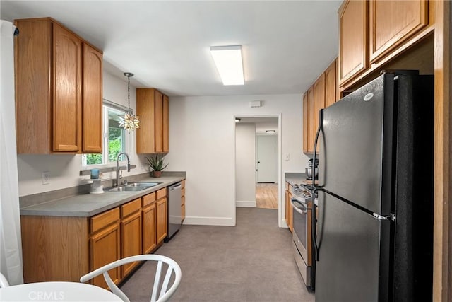 1516 Downing Ave, Chico, CA 95926 - kitchen featuring appliances with stainless steel finishes, a sink, brown cabinetry, baseboards, and hanging light fixtures