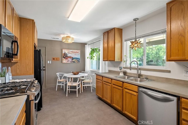 1516 Downing Ave, Chico, CA 95926 - kitchen with black appliances, a sink, brown cabinets, pendant lighting, and light countertops