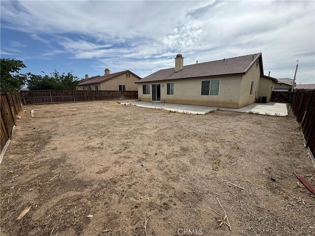 14543 Handsdale St, Adelanto, CA 92301 - rear view of property with a patio, a fenced backyard, a chimney, and a tiled roof