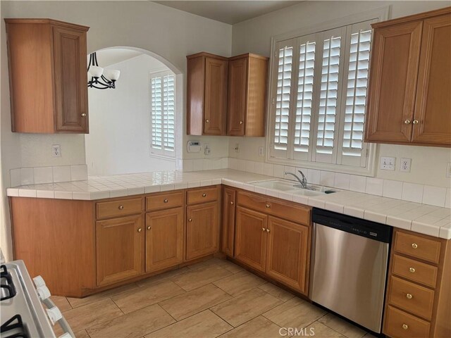 14543 Handsdale St, Adelanto, CA 92301 - kitchen featuring stainless steel dishwasher, a sink, brown cabinetry, and arched walkways