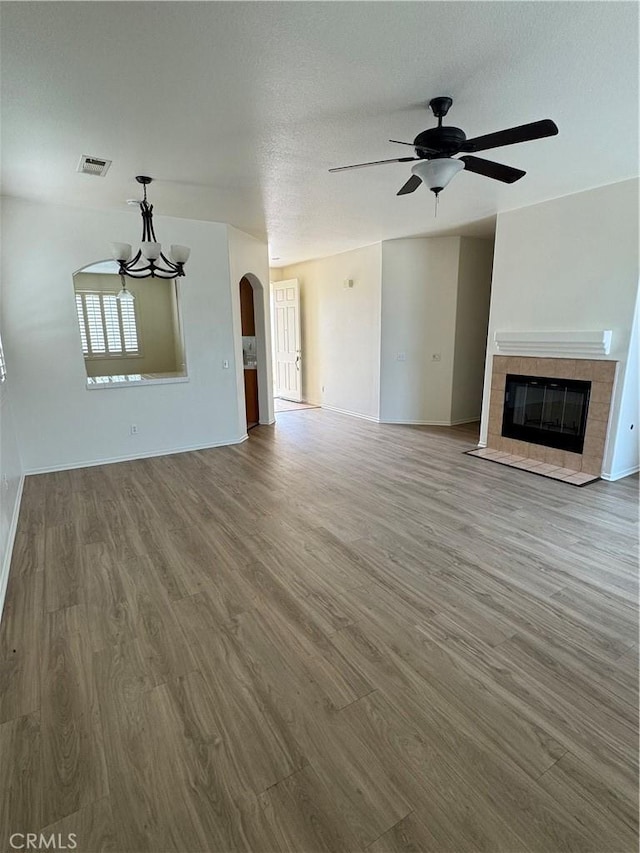 14543 Handsdale St, Adelanto, CA 92301 - unfurnished living room featuring wood finished floors, a chandelier, baseboards, ceiling fan, and a tiled fireplace