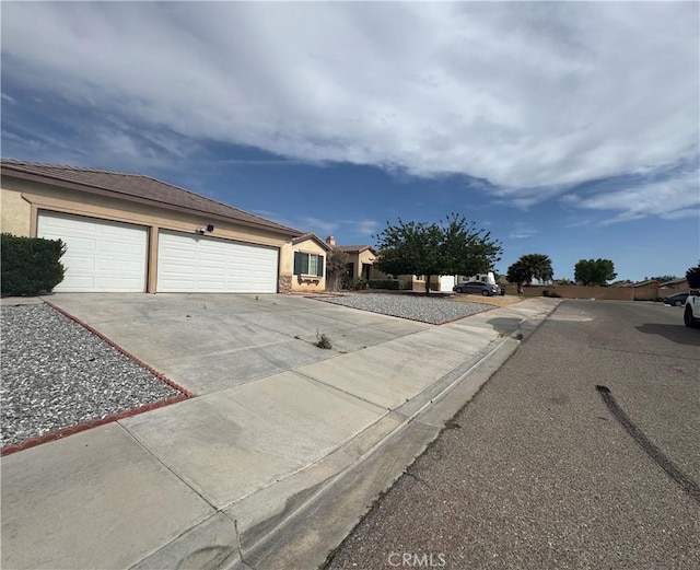 14543 Handsdale St, Adelanto, CA 92301 - view of front facade with driveway, stucco siding, and an attached garage