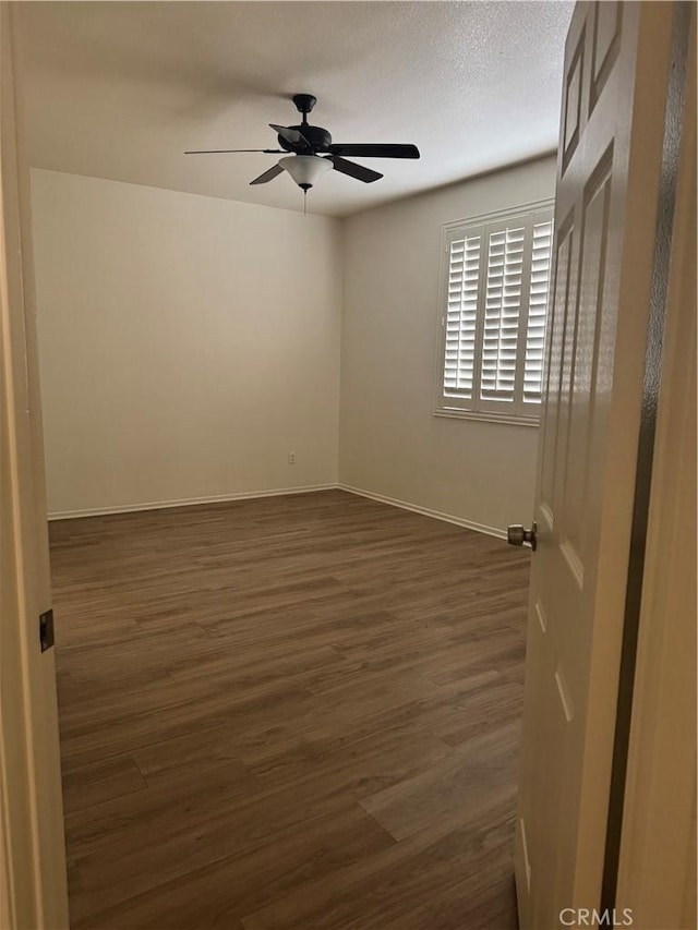 14543 Handsdale St, Adelanto, CA 92301 - unfurnished room with ceiling fan, dark wood-style floors, and baseboards