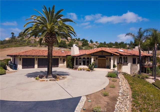 28306 Crescent Hill Way, Escondido, CA 92026 - mediterranean / spanish home with stucco siding, curved driveway, a tiled roof, a chimney, and an attached garage
