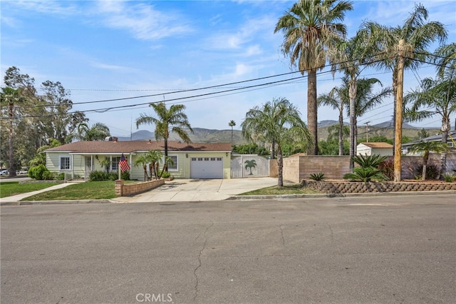 4909 Sepulveda Ave, San Bernardino, CA 92404 - single story home featuring concrete driveway, a mountain view, and a garage