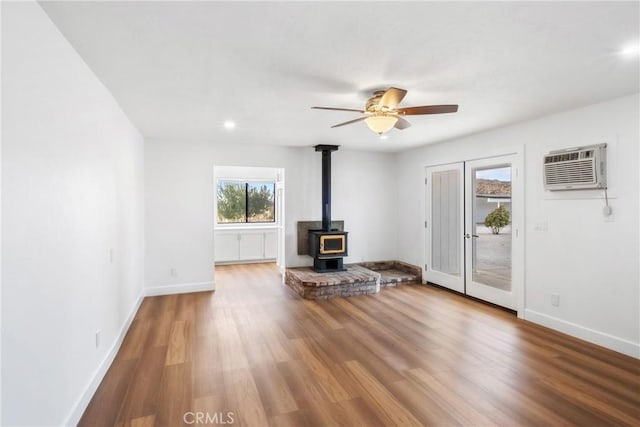 14040 Oden Dr, Apple Valley, CA 92307 - unfurnished living room featuring a wood stove, baseboards, wood finished floors, ceiling fan, and recessed lighting