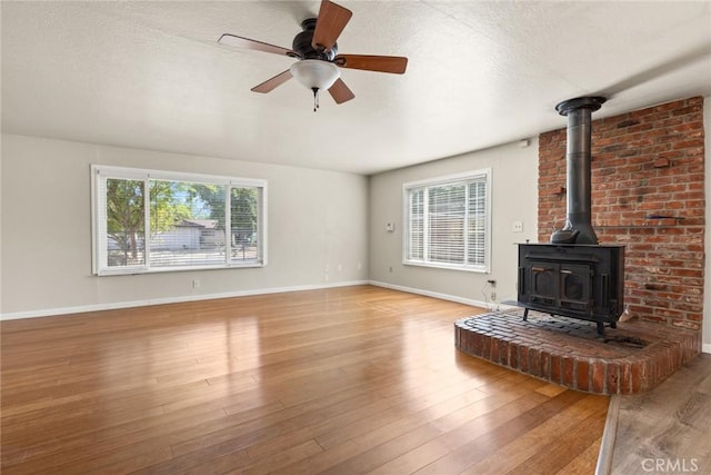 2 Comstock Rd, Chico, CA 95928 - unfurnished living room with plenty of natural light, a wood stove, wood finished floors, and a ceiling fan