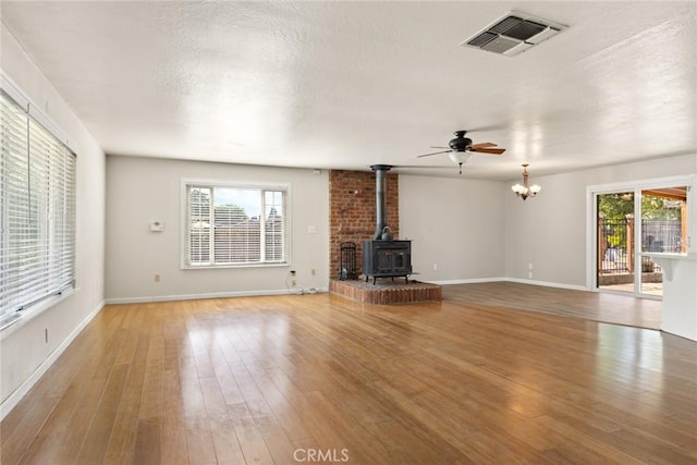 2 Comstock Rd, Chico, CA 95928 - unfurnished living room featuring a wood stove, plenty of natural light, light wood-style flooring, and baseboards