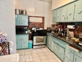 720 Le Borgne Ave, La Puente, CA 91746 - kitchen with gas stove, dark countertops, light tile patterned floors, and backsplash