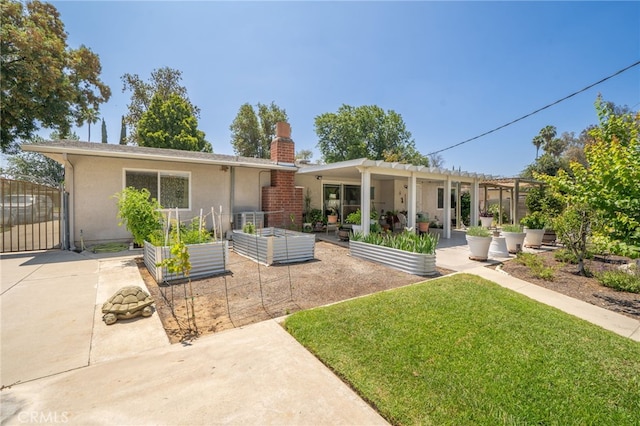 7191 Nixon Dr, Riverside, CA 92504 - rear view of house with a vegetable garden, a chimney, a yard, a patio area, and stucco siding