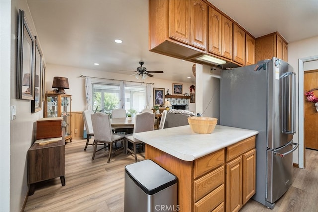 7191 Nixon Dr, Riverside, CA 92504 - kitchen with freestanding refrigerator, a fireplace, light wood-type flooring, a ceiling fan, and brown cabinetry