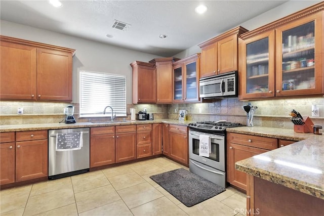 26822 Corona Dr, Helendale, CA 92342 - kitchen featuring appliances with stainless steel finishes, a sink, backsplash, light stone countertops, and recessed lighting