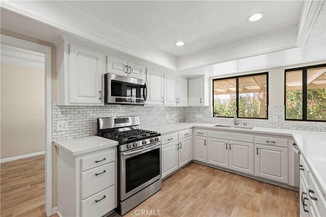 31681 Indian Oak Rd, Acton, CA 93510 - kitchen featuring stainless steel appliances, a sink, light countertops, white cabinetry, and light wood-type flooring