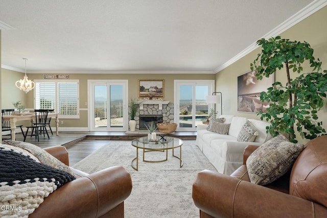 12983 Camden Ct, Moorpark, CA 93021 - living area featuring crown molding, a chandelier, wood finished floors, a stone fireplace, and baseboards