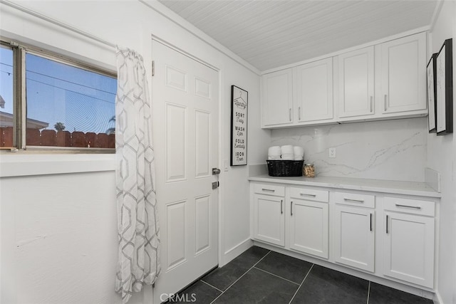 217 N Mcclay St, Santa Ana, CA 92701 - kitchen with white cabinets, light countertops, dark tile patterned floors, and tasteful backsplash