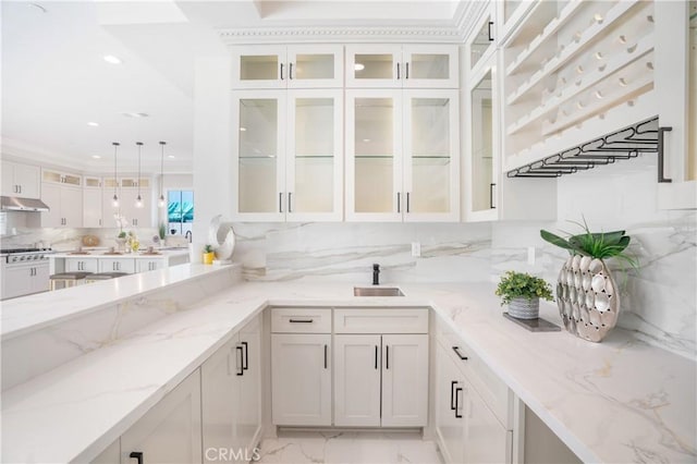 5305 Glickman Ave, Temple City, CA 91780 - kitchen with under cabinet range hood, white cabinetry, tasteful backsplash, decorative light fixtures, and light stone countertops