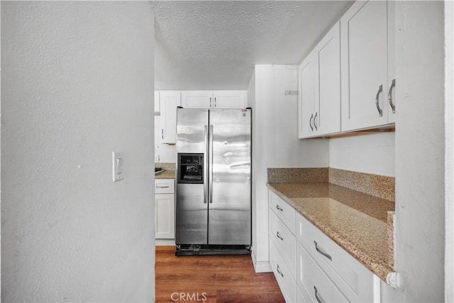 5331 Vallecito Ave, Westminster, CA 92683 - kitchen with stainless steel fridge, dark wood-style floors, white cabinets, a textured ceiling, and light stone counters
