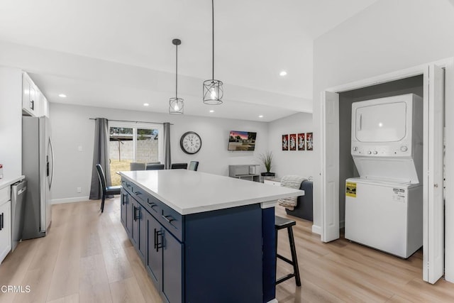 7745 Geyser Ave, Reseda, CA 91335 - kitchen with stacked washer / dryer, stainless steel appliances, light wood finished floors, a center island, and recessed lighting