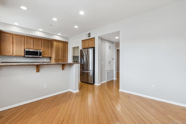 3023 Pacific Palm Way, San Diego, CA 92117 - kitchen with appliances with stainless steel finishes, a breakfast bar area, stone counters, baseboards, and recessed lighting