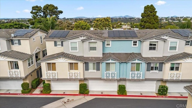 3023 Pacific Palm Way, San Diego, CA 92117 - multi unit property featuring stucco siding, an attached garage, roof mounted solar panels, a mountain view, and a tiled roof