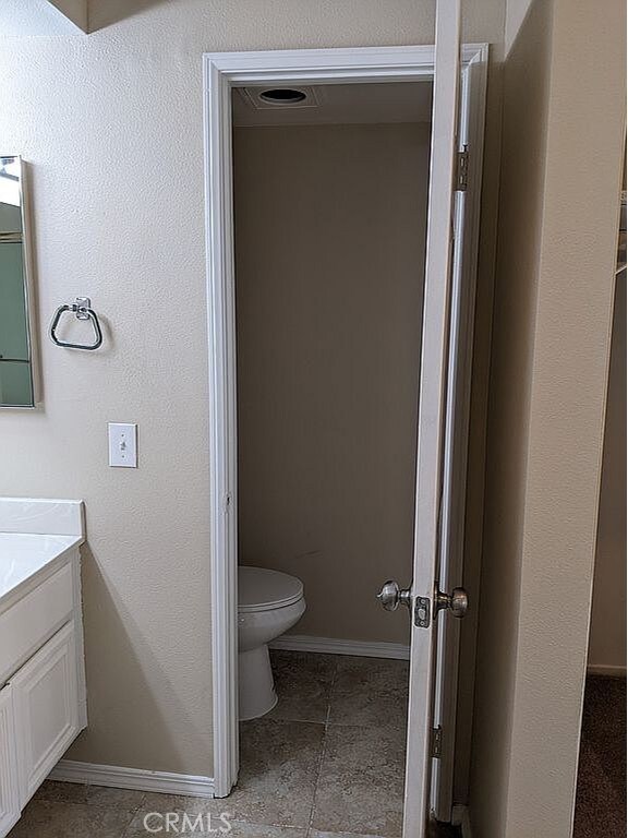 37713 57th St E, Palmdale, CA 93552 - bathroom featuring toilet, vanity, and baseboards