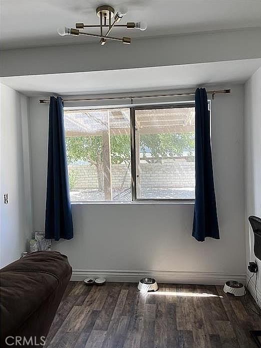 37713 57th St E, Palmdale, CA 93552 - spare room with wood finished floors, a chandelier, and baseboards
