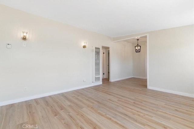 12074 Lee Ave, Adelanto, CA 92301 - spare room featuring a heating unit, light wood-type flooring, and baseboards