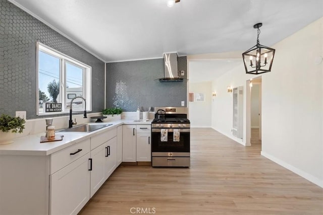 12074 Lee Ave, Adelanto, CA 92301 - kitchen featuring gas range, a sink, wall chimney range hood, wallpapered walls, and light wood-type flooring