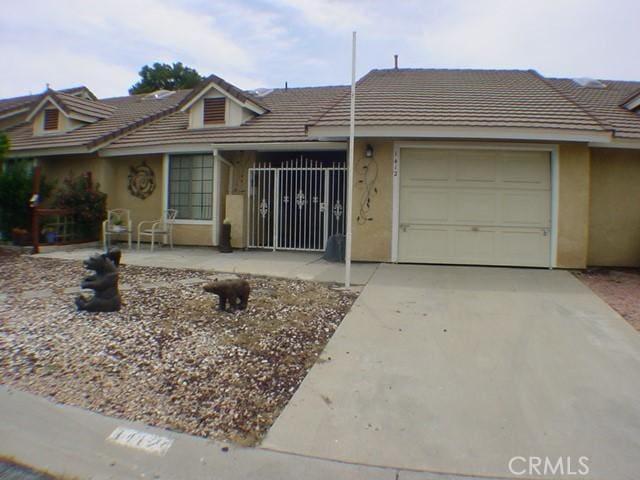 1412 Colonial Way, San Jacinto, CA 92583 - view of front facade with a garage, stucco siding, concrete driveway, and a tiled roof