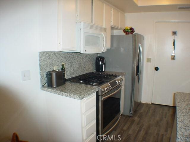 1412 Colonial Way, San Jacinto, CA 92583 - kitchen featuring white microwave, stainless steel gas range, tasteful backsplash, dark wood finished floors, and white cabinetry
