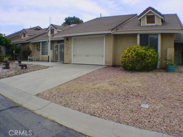 1412 Colonial Way, San Jacinto, CA 92583 - ranch-style house featuring an attached garage, stucco siding, driveway, and a tile roof