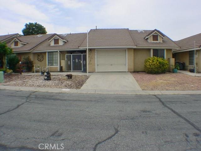1412 Colonial Way, San Jacinto, CA 92583 - view of front facade with driveway, a garage, a tiled roof, and stucco siding