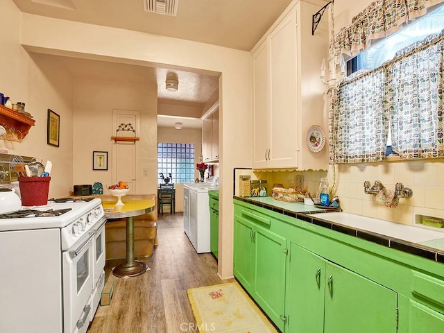 639 Magnolia Ave, Inglewood, CA 90301 - kitchen with white range with gas stovetop, washer / dryer, light wood finished floors, tile countertops, and tasteful backsplash