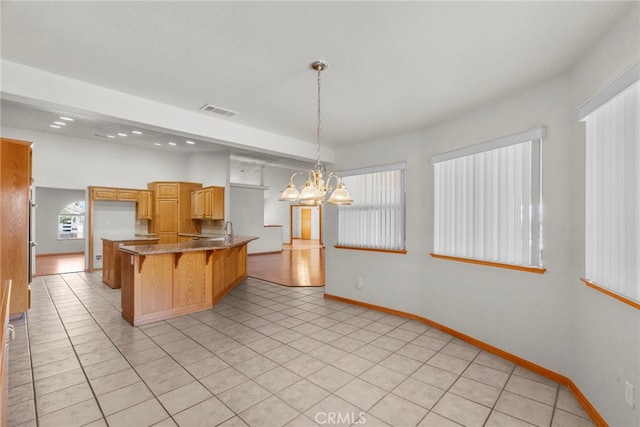 13209 Richmond Way, Apple Valley, CA 92308 - kitchen with a kitchen breakfast bar, a chandelier, a peninsula, and light tile patterned floors