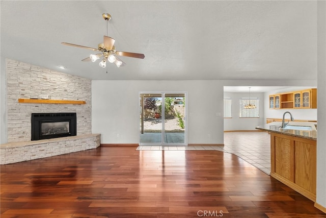 13209 Richmond Way, Apple Valley, CA 92308 - unfurnished living room with a sink, healthy amount of natural light, wood finished floors, a fireplace, and lofted ceiling