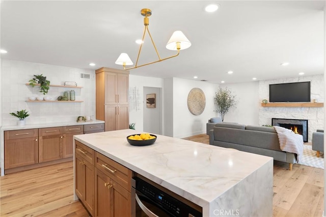 742 Hudson Ave, Costa Mesa, CA 92626 - kitchen with light wood-type flooring, open shelves, a stone fireplace, a kitchen island, and recessed lighting