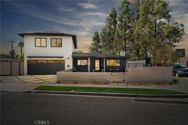 742 Hudson Ave, Costa Mesa, CA 92626 - view of front of property featuring driveway, roof mounted solar panels, a gate, a garage, and stucco siding
