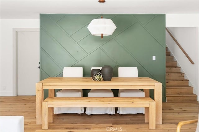 742 Hudson Ave, Costa Mesa, CA 92626 - dining room with a decorative wall, stairway, and light wood-style floors