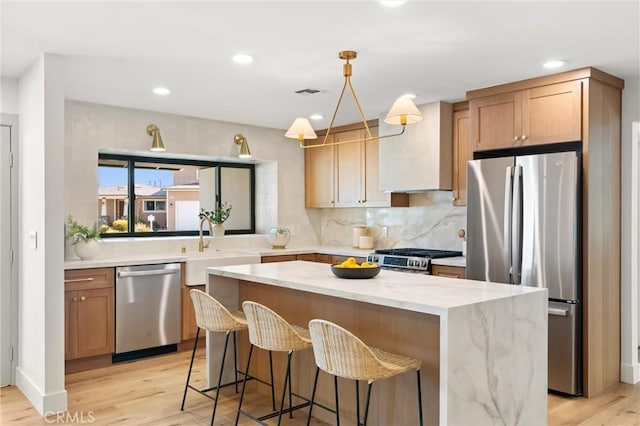 742 Hudson Ave, Costa Mesa, CA 92626 - kitchen featuring appliances with stainless steel finishes, premium range hood, light wood-type flooring, a kitchen island, and recessed lighting