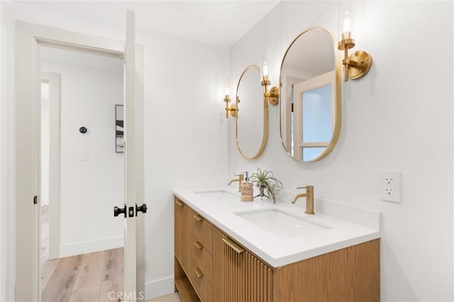 742 Hudson Ave, Costa Mesa, CA 92626 - bathroom with double vanity, wood finished floors, and baseboards