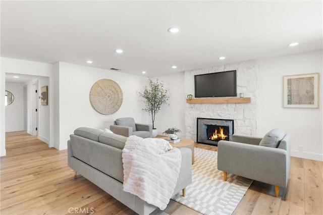 742 Hudson Ave, Costa Mesa, CA 92626 - living area with light wood finished floors, a stone fireplace, recessed lighting, and baseboards